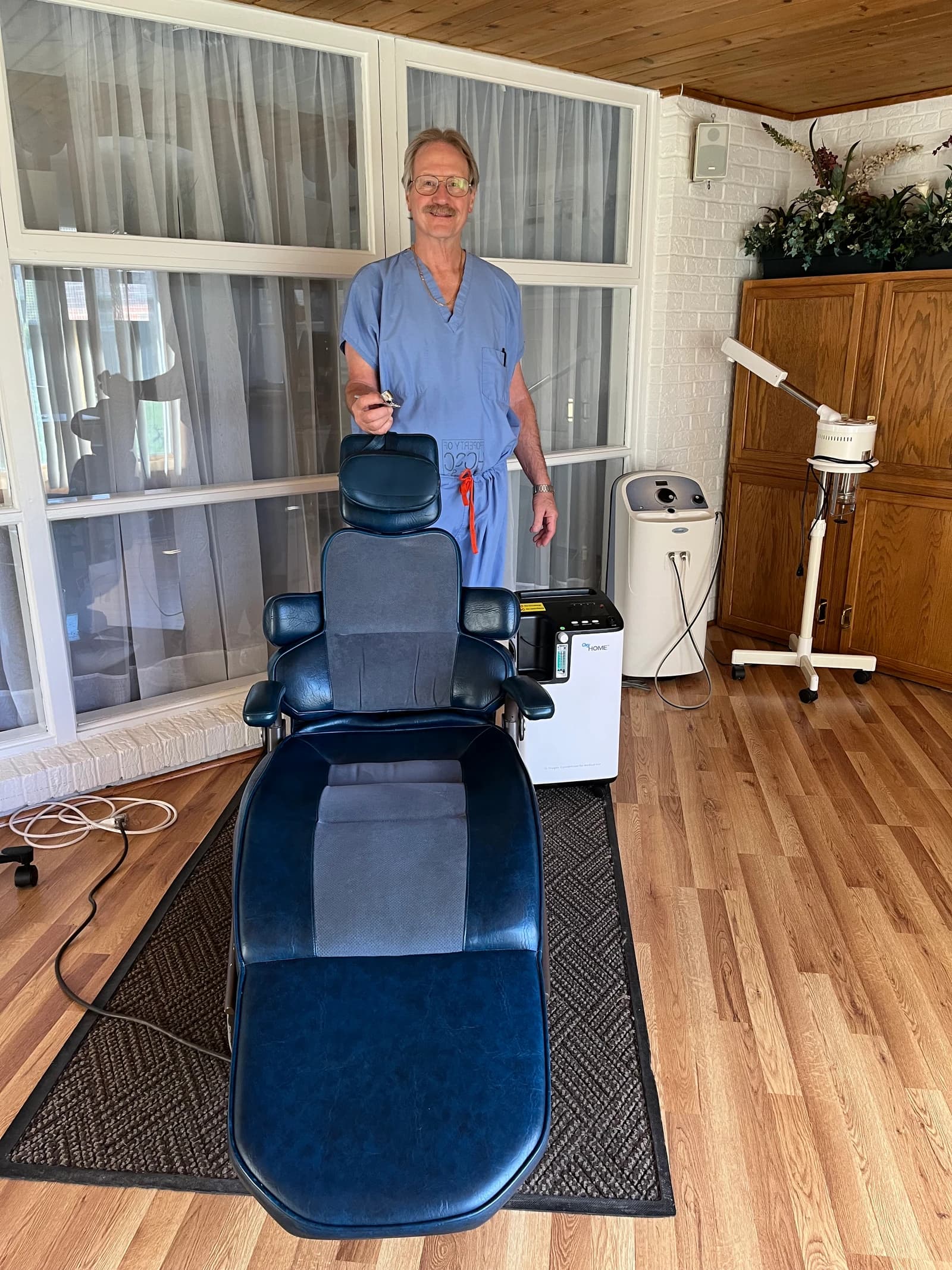 Dr. Scott Sackman beside the oxygen facial treatment chair at Enhancements